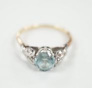 A yellow metal, plat and single stone blue zircon ring, with diamond chip set petal shoulders,