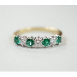 A modern 18ct gold, four stone emerald and three stone diamond set half hoop ring, size M, gross