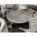 A weathered teak circular garden table, diameter 150cm, height 75cm and three elbow chairs