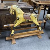 A small early 20th century Ayres type rocking horse on pine safety frame, length 99cm, height 79cm