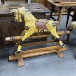 A small early 20th century Ayres type rocking horse on pine safety frame, length 99cm, height 79cm