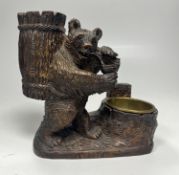 A carved Black Forest bear smokers stand with pipe rest and brass lined ashtray, signed Adel