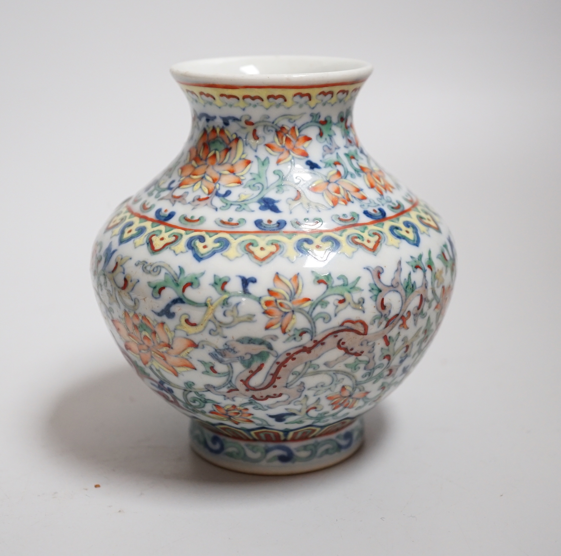 A small Chinese doucai jar, decorated with dragons and lotus flowers, housed in a fitted case, 12.