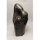 A Zimbabwe soapstone carving of two embracing figures, signed B Nehlimba, 53cm high