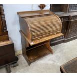An early 20th century oval tambour roll top desk, combined bookcase, width 75cm, depth 53cm,