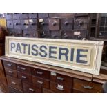 A rectangular painted wood “Patisserie” shop sign, width 147cm, height 34cm.