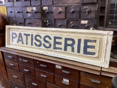 A rectangular painted wood “Patisserie” shop sign, width 147cm, height 34cm.