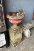 A pair of Victorian terracotta and stone campana garden urns on stands, one with losses, larger