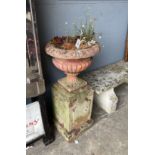 A pair of Victorian terracotta and stone campana garden urns on stands, one with losses, larger