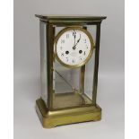 An early 20th century French brass four-glass mantel clock with enamel dial inscribed Garnier,