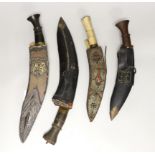 A kukri within white metal mounted sheath, blade 27cm, and three others, one with bone handle