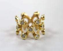 A modern yellow metal and diamond cluster set lattice work dress ring, size L/M, gross weight 12.7