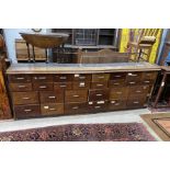 An apothecary bank of twenty eight drawers, now in two sections, length 260cm, depth 41cm, height
