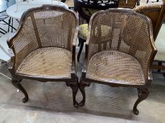 A pair of Queen Anne revival walnut cane seat tub framed bergere armchairs, width 55cm, depth