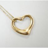 A modern Tiffany & Co 18ct gold and single stone diamond set openwork heart pendant, 20mm, on an