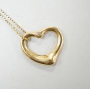 A modern Tiffany & Co 18ct gold and single stone diamond set openwork heart pendant, 20mm, on an