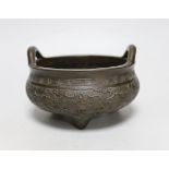 A Chinese twin handled bronze tripod censer, ding, Xuande mark, 19th century, decorated in relief