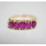 An early to mid 20th century 18ct and graduated five stone ruby set half hoop ring, with diamond