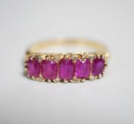 An early to mid 20th century 18ct and graduated five stone ruby set half hoop ring, with diamond