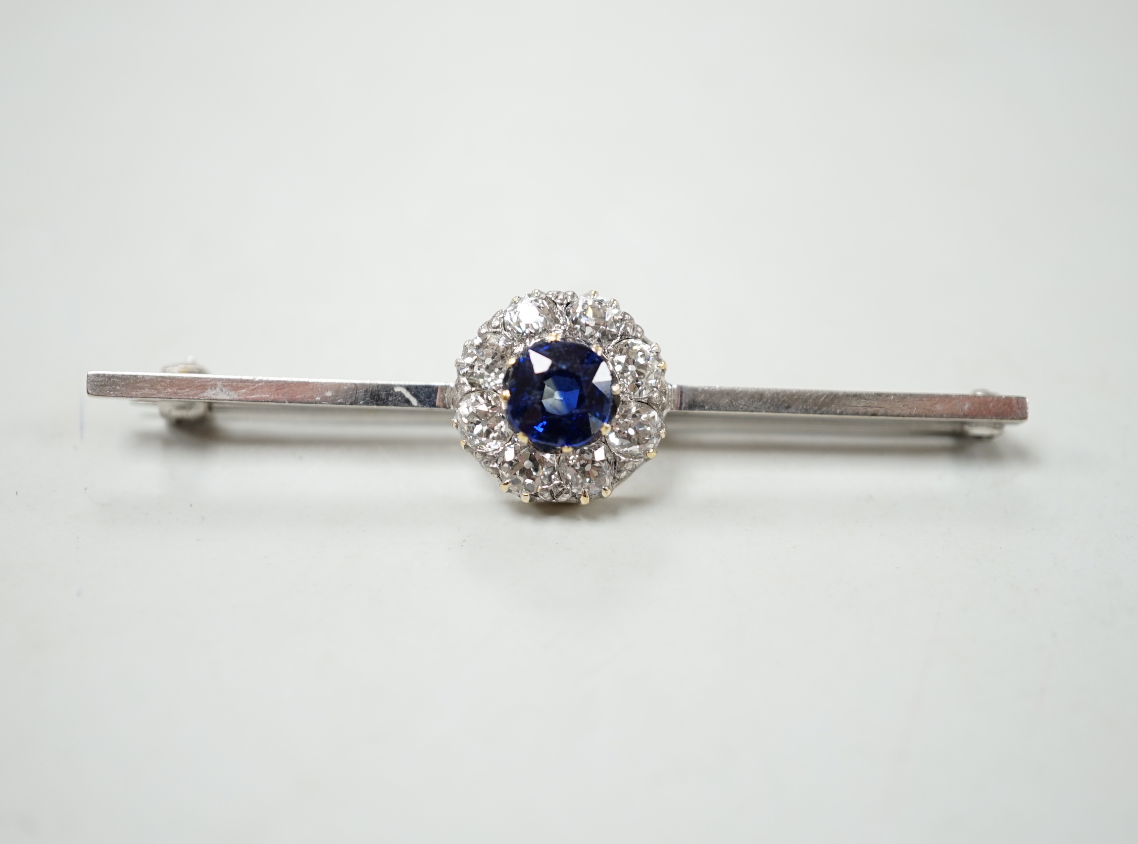 A mid 20th century white metal, sapphire and diamond cluster set bar brooch, 55mm, gross weight 4.