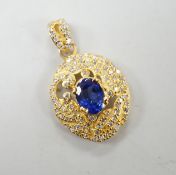 A modern 14k yellow metal, synthetic? sapphire and diamond cluster set oval pendant, overall 28mm,