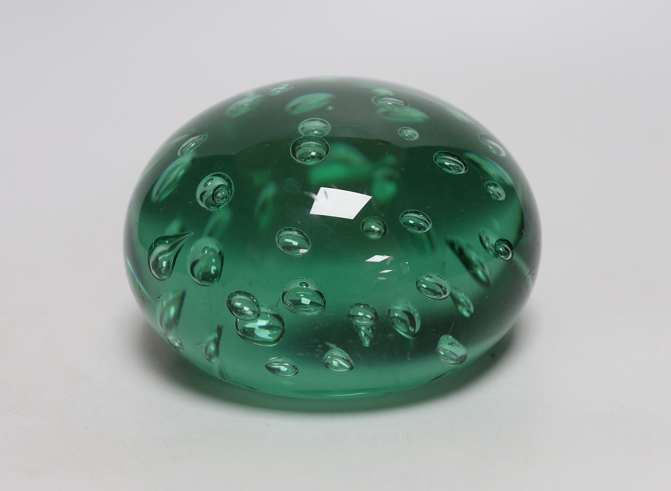 A green glass dump weight, 14cm in diameter