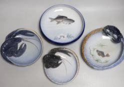 Four Royal Copenhagen dishes, one decorated with fish, two with lobsters and another with a crab,