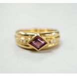 A modern 750 yellow metal and single stone diamond shaped garnet set ring, with diamond set