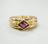 A modern 750 yellow metal and single stone diamond shaped garnet set ring, with diamond set