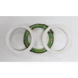 Three Chinese bangles, two in white and one in green with applied brass ring and dragons