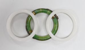Three Chinese bangles, two in white and one in green with applied brass ring and dragons