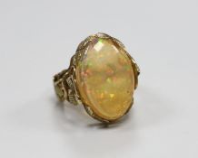 A yellow metal and oval jelly? opal set dress ring, with rustic foliate shank and setting, size L,