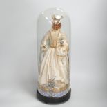 A waxed dressed figure with crown holding a baby under a glass dome 49.5cm high