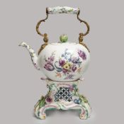 A mid 18th century Meissen teapot on a later Dresden stand with brass handle and floral