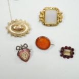 Five assorted antique brooches, comprising an early 19th century foiled ruby and hair work heart