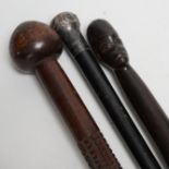 A silver topped walking cane and two African carved wood canes
