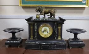 An early 20th century black slate clock garniture with metal lion mount, clock 37cm high
