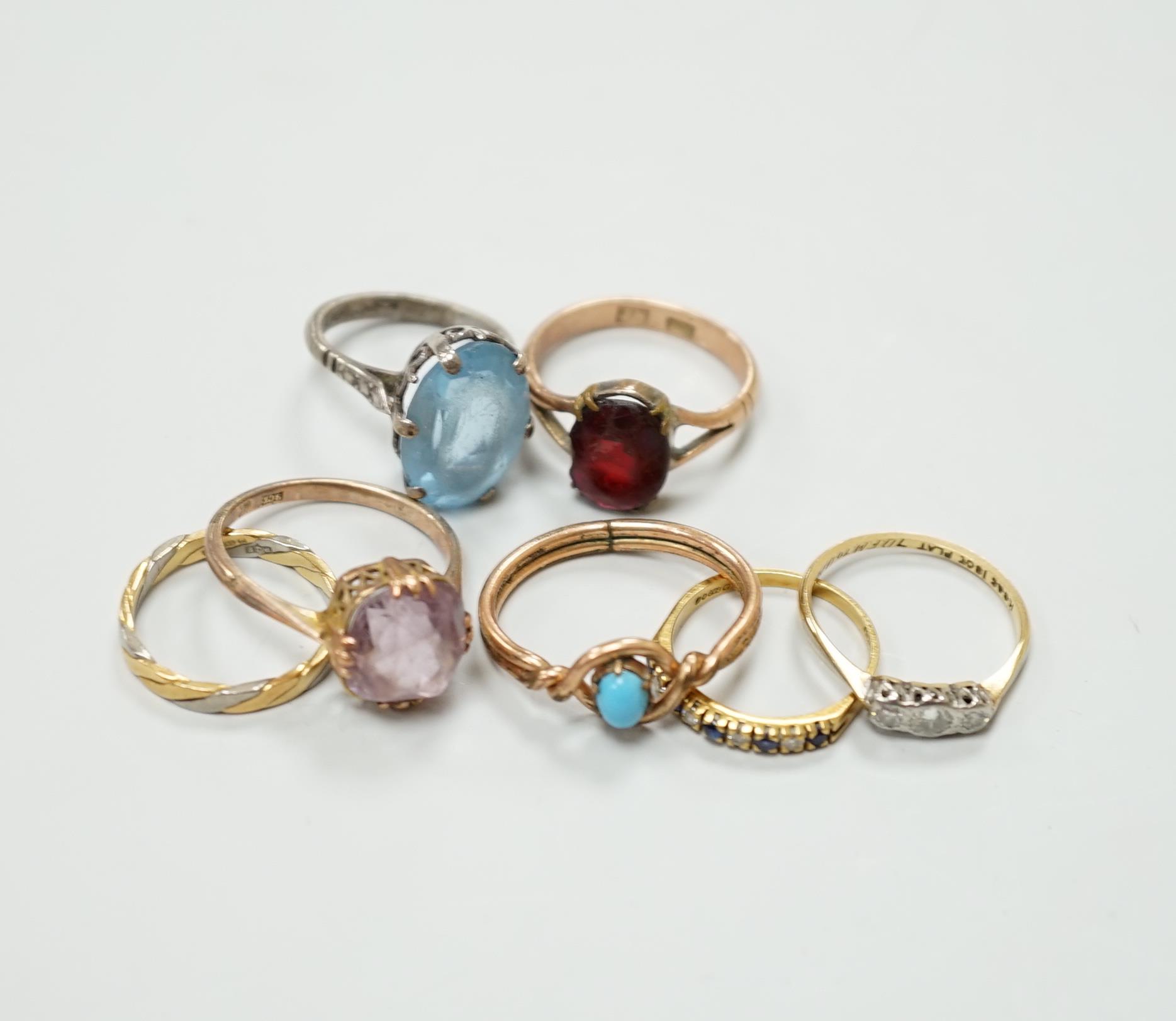 Seven assorted dress rings, comprising an 18ct gold three stone diamond ring, size M, a 9ct gold