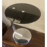 A chrome and black glass circular occasional table, diameter 45cm, height 54cm