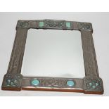 A Miller Brothers Art Nouveau embossed pewter mirror with cabochon turquoise enamel bosses, 48cm