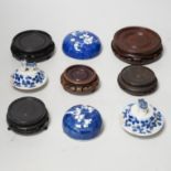 A group of Chinese wooden stands and ceramic lids