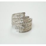 A 9ct white gold and dress ring designed with nine bands of brilliant and baguette cut stones,