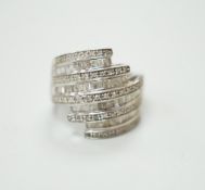 A 9ct white gold and dress ring designed with nine bands of brilliant and baguette cut stones,