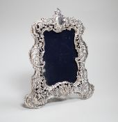 An Edwardian cast silver photograph frame, decorated and pierced with flowers and scrolls,