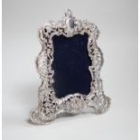 An Edwardian cast silver photograph frame, decorated and pierced with flowers and scrolls,