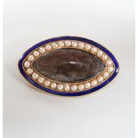 A Regency gold, enamel and split pearl brooch, of elliptical form with hairwork panel and monogram