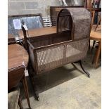 A Regency caned mahogany rocking crib, length 100cm, height 123cm