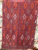 A North West Persian Jadjim geometric red ground carpet 284cm x 140cm