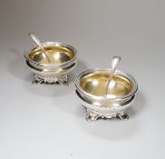 A pair of Victorian circular silver salts, with crests and scroll feet, makers Edward Barnard &