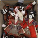 A collection of Japanese gofun dolls, some wearing kimonos, the largest 30cm high